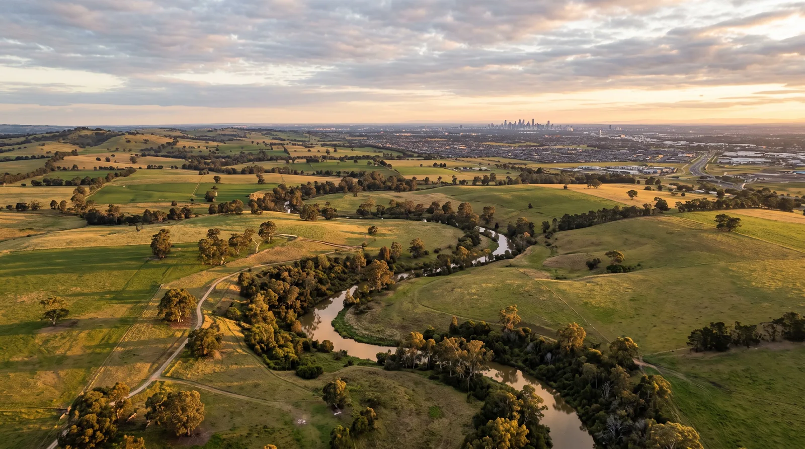 Aerial view over open grassland and creek country on Melbourne's western fringe